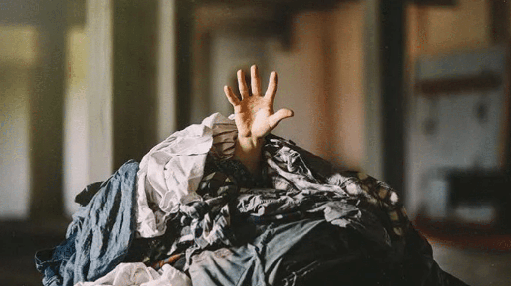 Main enfant dans tas de vêtements