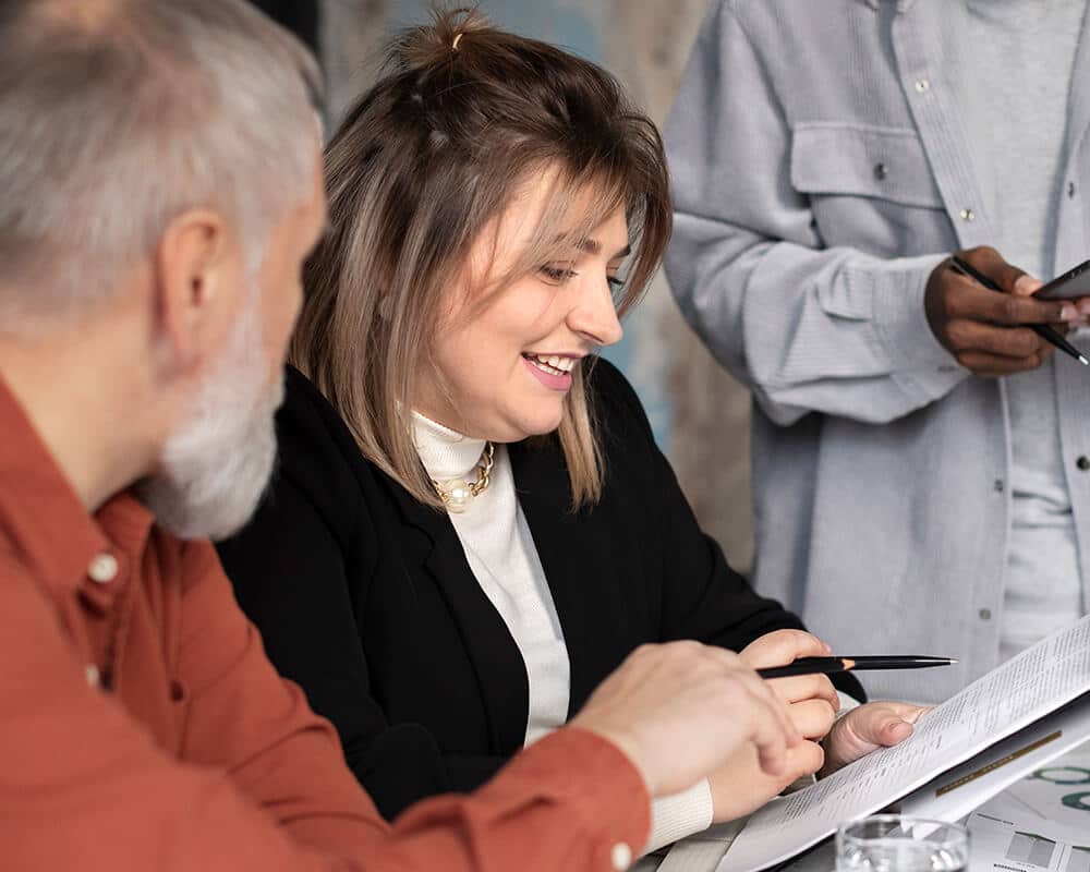 illustration-etape-avenir-pro Une femme souriante montre un document à un homme plus âgé à côté d'elle