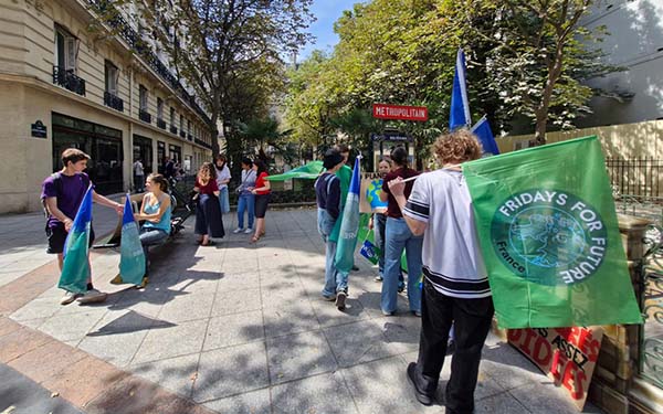 groupe de lycéen rassemblé devant un arrêt de métro avec des drapeau "fridays for the future"